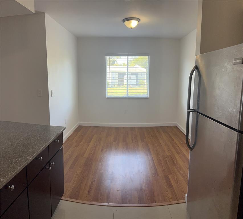 13300 Walsingham Road, Unit 6 Largo, FL 33774 - Photo 3 of 21 an empty room with wooden floor and cabinet
