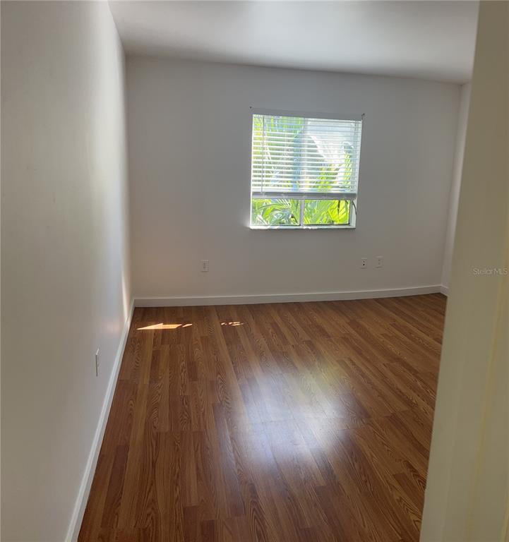 13300 Walsingham Road, Unit 6 Largo, FL 33774 - Photo 6 of 21 an empty room with wooden floor and windows