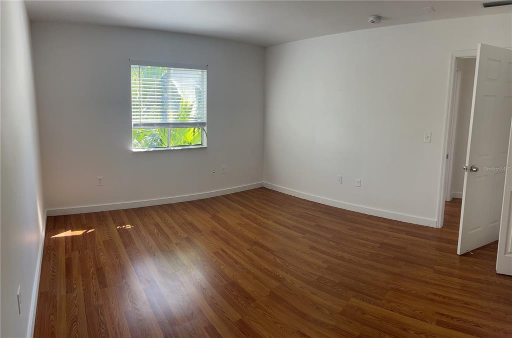 13300 Walsingham Road, Unit 6 Largo, FL 33774 - Photo 7 of 21 an empty room with wooden floor and window