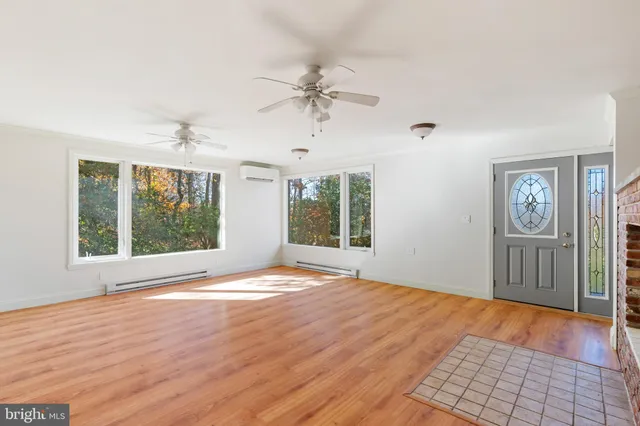 a large white kitchen with granite countertop a stove a sink a window and stainless steel appliances