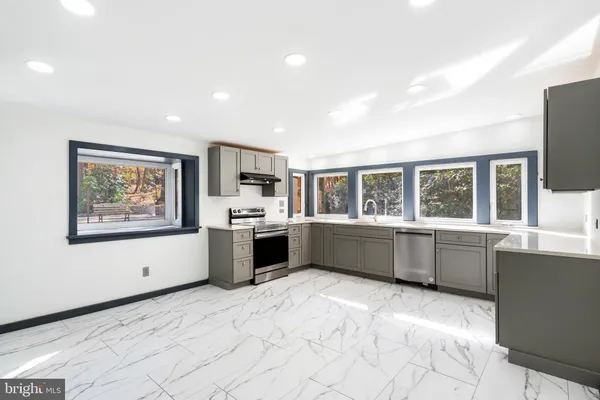 a kitchen with a sink and large window with a garden view