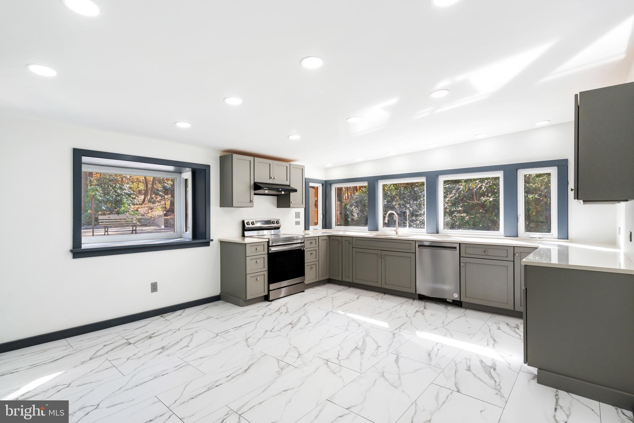 3211 Pricetown Road Fleetwood, PA 19522 - Photo 18 of 71 a large white kitchen with granite countertop a stove a sink a window and stainless steel appliances