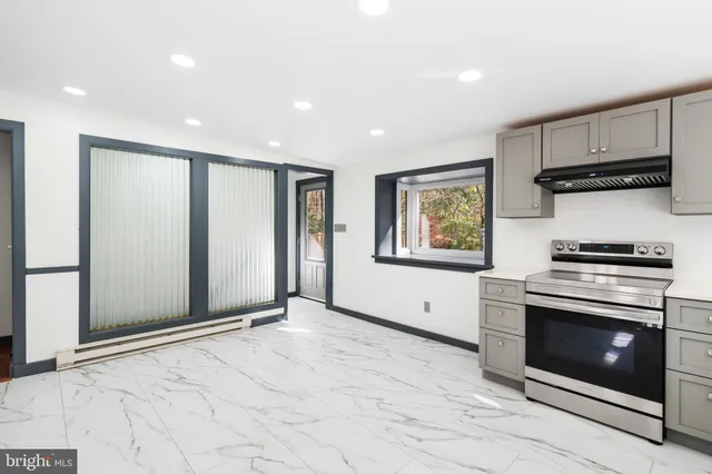 a bathroom with a toilet a sink a mirror a vanity and shower