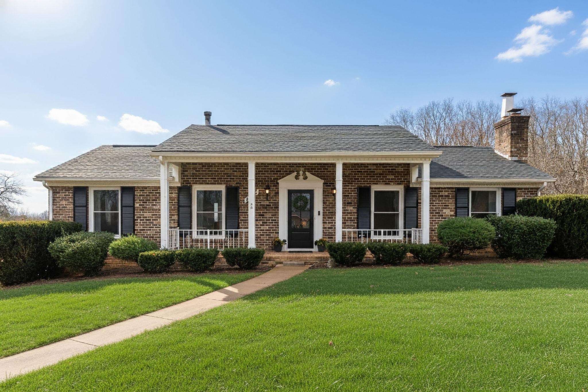 a front view of a house with garden and porch