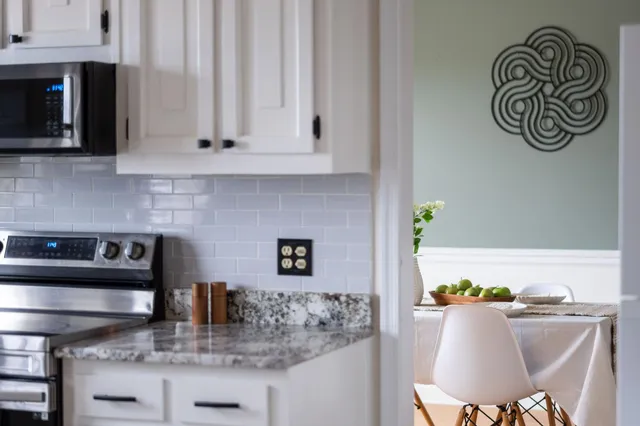 a kitchen with stainless steel appliances granite countertop a stove a microwave a sink and cabinets