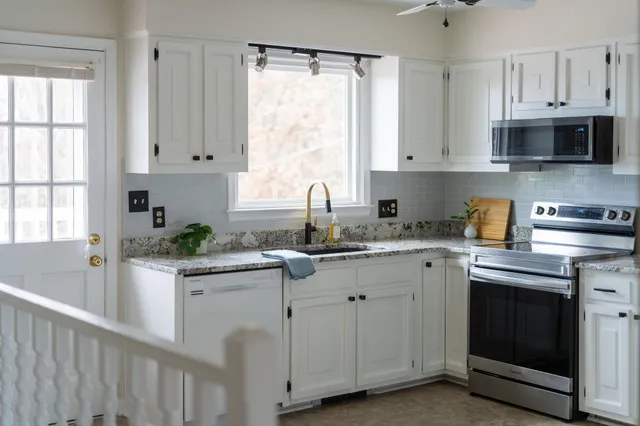 a kitchen with appliances a sink and a window