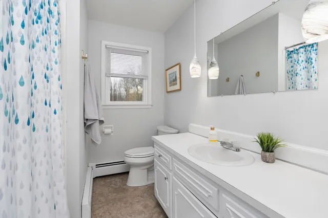 a bathroom with a granite countertop sink and a toilet