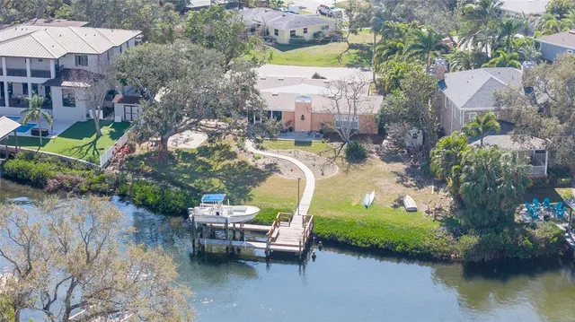 an aerial view of a house with a garden and lake view