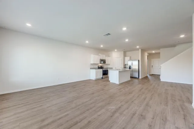 a view of kitchen with kitchen island and stainless steel appliances refrigerator