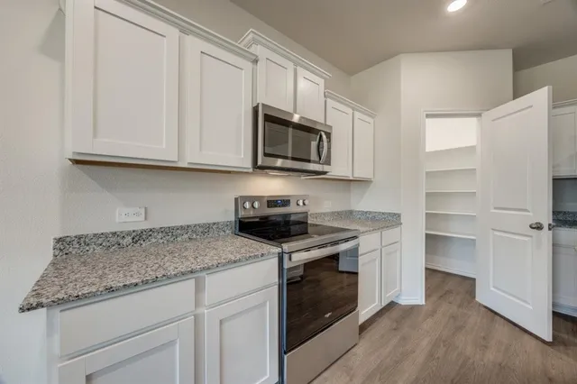 a kitchen with stainless steel appliances granite countertop a sink stove and cabinets