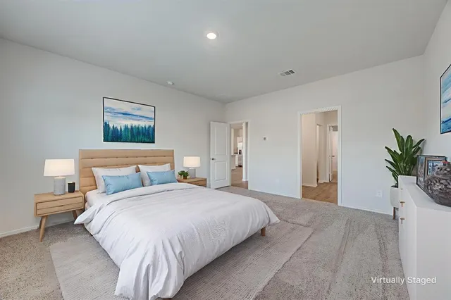 a bedroom with a large bed and a potted plant