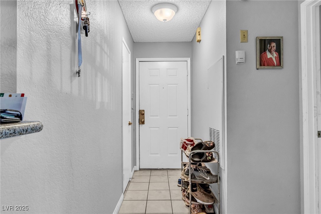 2200 South Fort Apache Road, Unit 1007 Las Vegas, NV 89117 - Photo 4 of 30 Doorway with light tile patterned floors and a textured ceiling