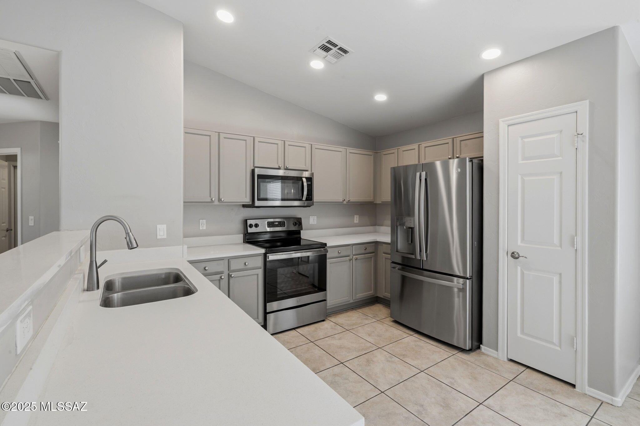 8244 South Lost Mountain Road Tucson, AZ 85747 - Photo 8 of 41 a kitchen with granite countertop a refrigerator and a sink