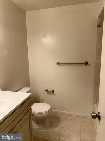 a bathroom with a granite countertop toilet and a sink