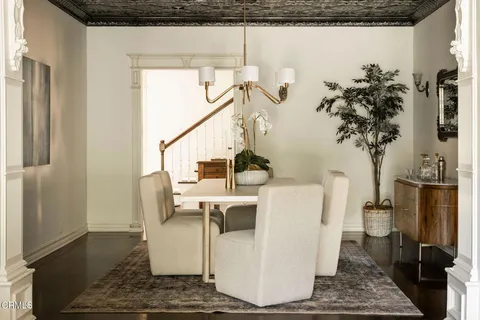 a kitchen with stainless steel appliances granite countertop a stove top oven a sink dishwasher and a dining table with wooden floor