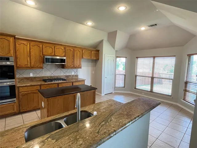 a kitchen with stainless steel appliances granite countertop a sink stove and cabinets