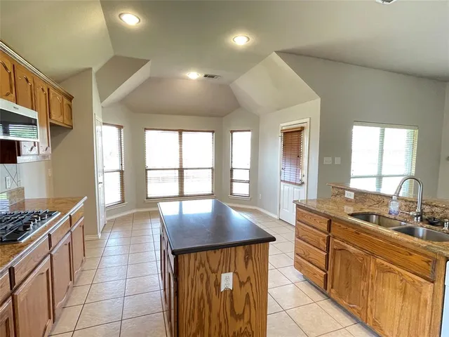 a kitchen with stainless steel appliances granite countertop a sink stove and cabinets