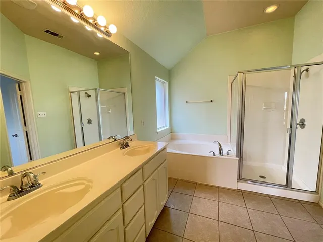 a spacious bathroom with a tub sink and mirror
