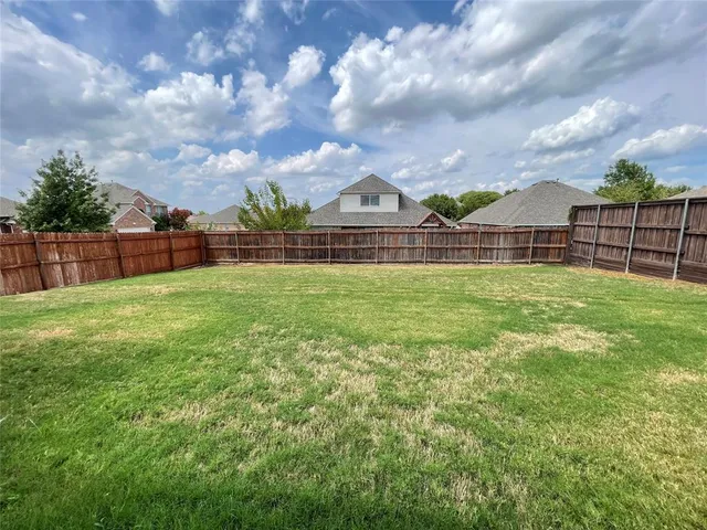 a view of a green field with wooden fence