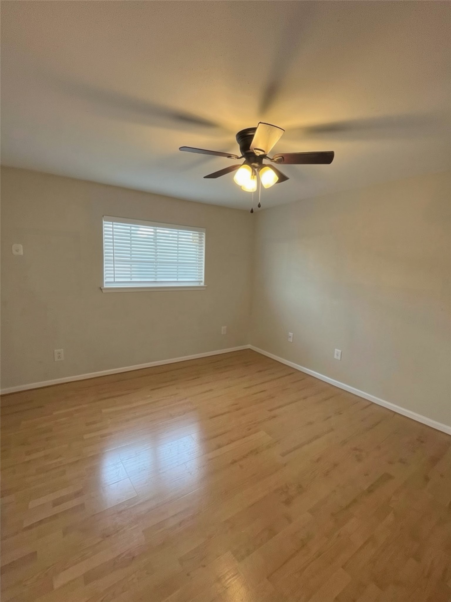 515 Tallowood Road, Unit 55 Houston, TX 77024 - Photo 14 of 18 an empty room with a chandelier fan and windows