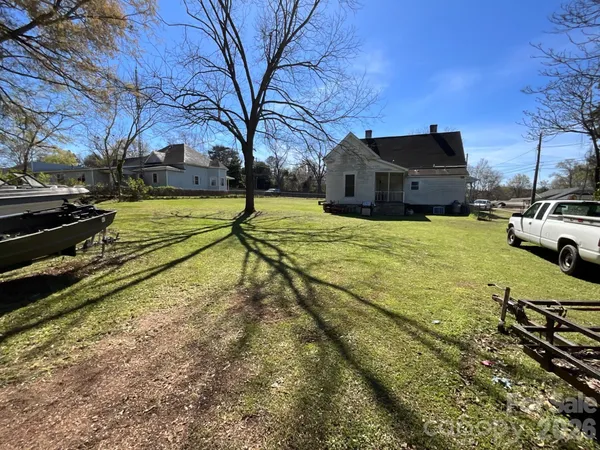 a view of a yard with wooden fence