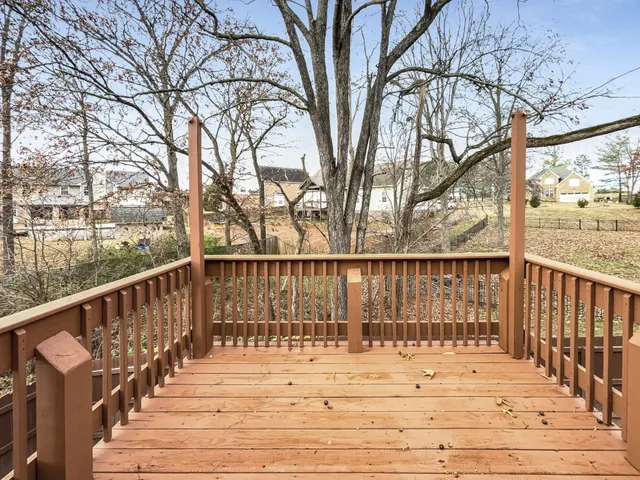 a view of balcony with wooden floor and fence and trees