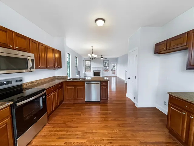a large kitchen with stainless steel appliances wooden floors and wooden cabinets
