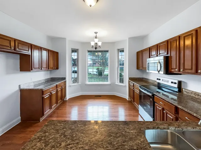 a kitchen with stainless steel appliances granite countertop a stove a sink dishwasher a microwave oven with granite countertops and cabinets