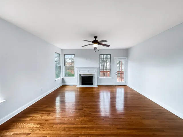 a view of empty room with wooden floor and fireplace