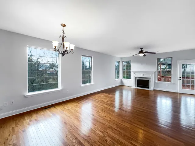 a view of empty room with wooden floor fireplace and windows