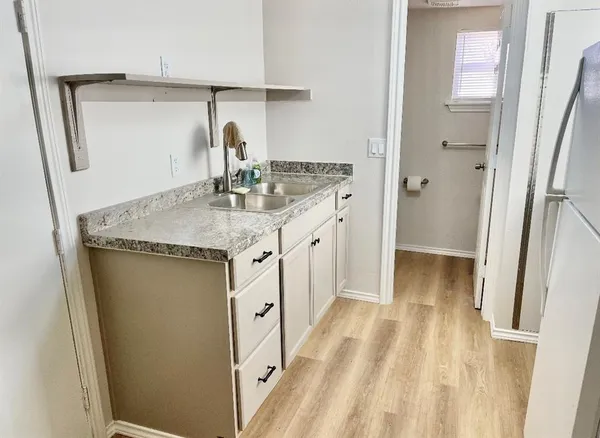 a bathroom with a granite countertop sink a mirror and shower