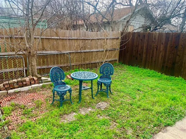 a backyard of a house with table and chairs