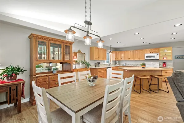 a dining table with chairs and kitchen view
