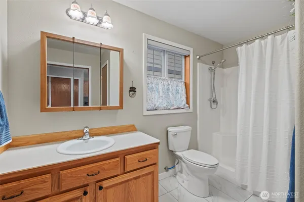 a bathroom with a granite countertop sink a toilet and a mirror