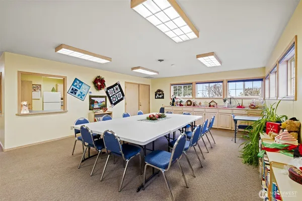 a view of a dining room and livingroom with furniture a rug a painting and a chandelier