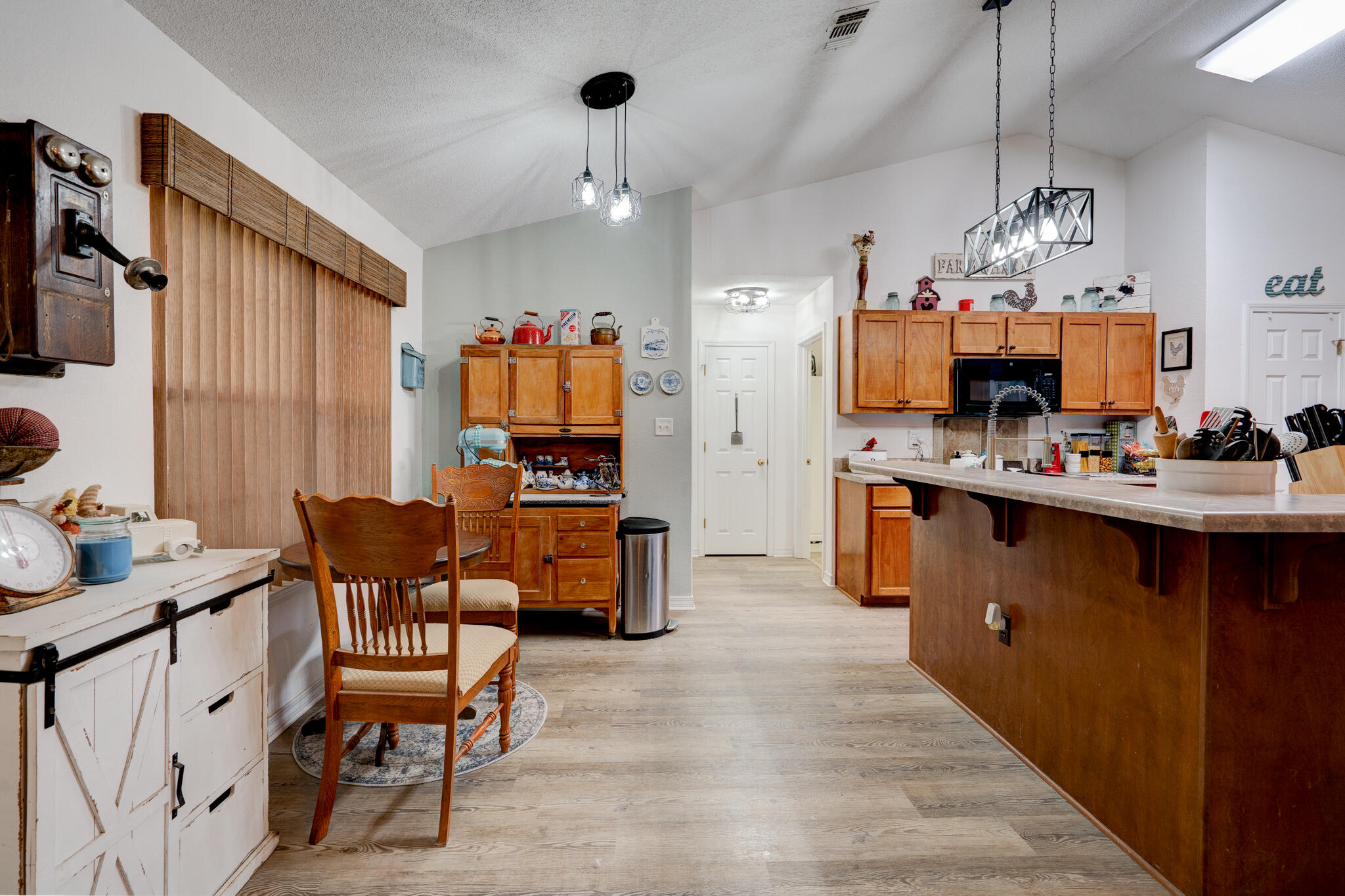 4173 Big Buck Trail Crestview, FL 32539 - Photo 8 of 38 a kitchen with stainless steel appliances kitchen island granite countertop a sink dishwasher a dining table and chairs with wooden floor