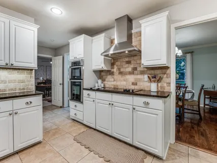 a kitchen with granite countertop a sink stainless steel appliances and cabinets