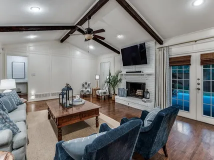 a living room with furniture a flat screen tv and a fireplace