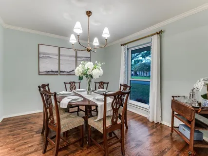 a view of a dining room with furniture wooden floor and chandelier