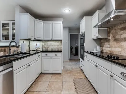 a kitchen with stainless steel appliances granite countertop a sink and cabinets
