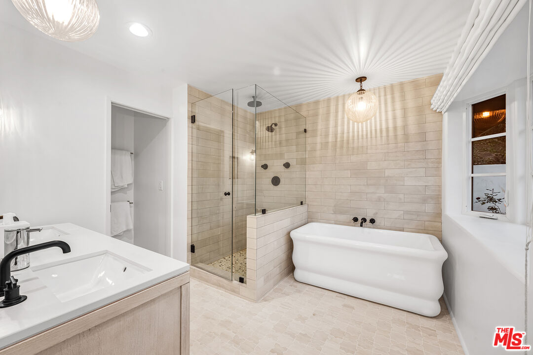 2382 Live Oak Meadows Road Malibu, CA 90265 - Photo 12 of 20 a bathroom with a tub a sink and a large mirror
