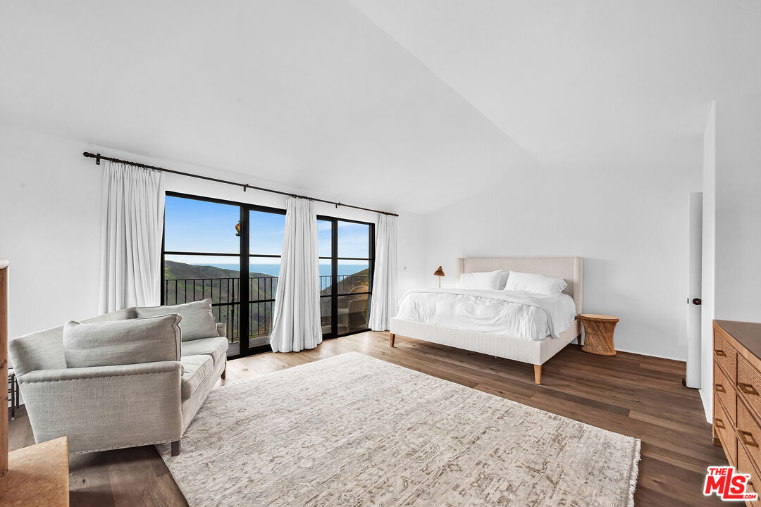2382 Live Oak Meadows Road Malibu, CA 90265 - Photo 10 of 20 a bedroom with a bed couch and wooden floor