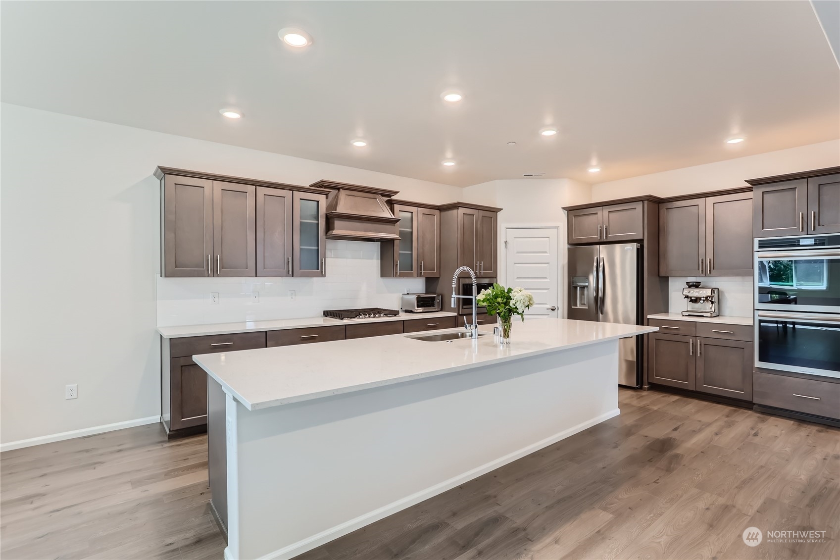 4126 235th Place Southeast Bothell, WA 98021 - Photo 10 of 28 a large white kitchen with kitchen island a sink a stove a refrigerator and a cabinets