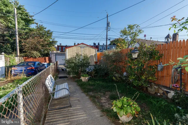 a balcony with couple of flower plants and wooden fence