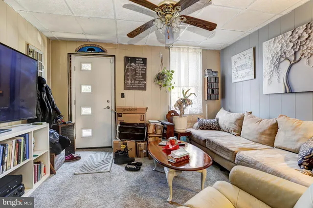a living room with furniture a flat screen tv and a bookshelf