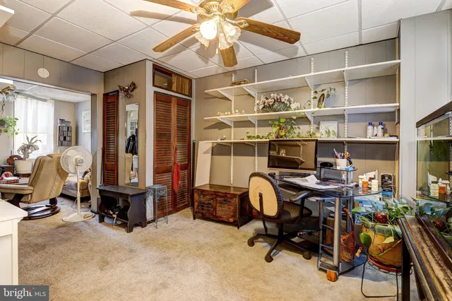 a view of a workspace with furniture and a window