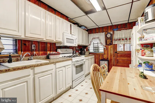 a kitchen with granite countertop a sink a stove and cabinets