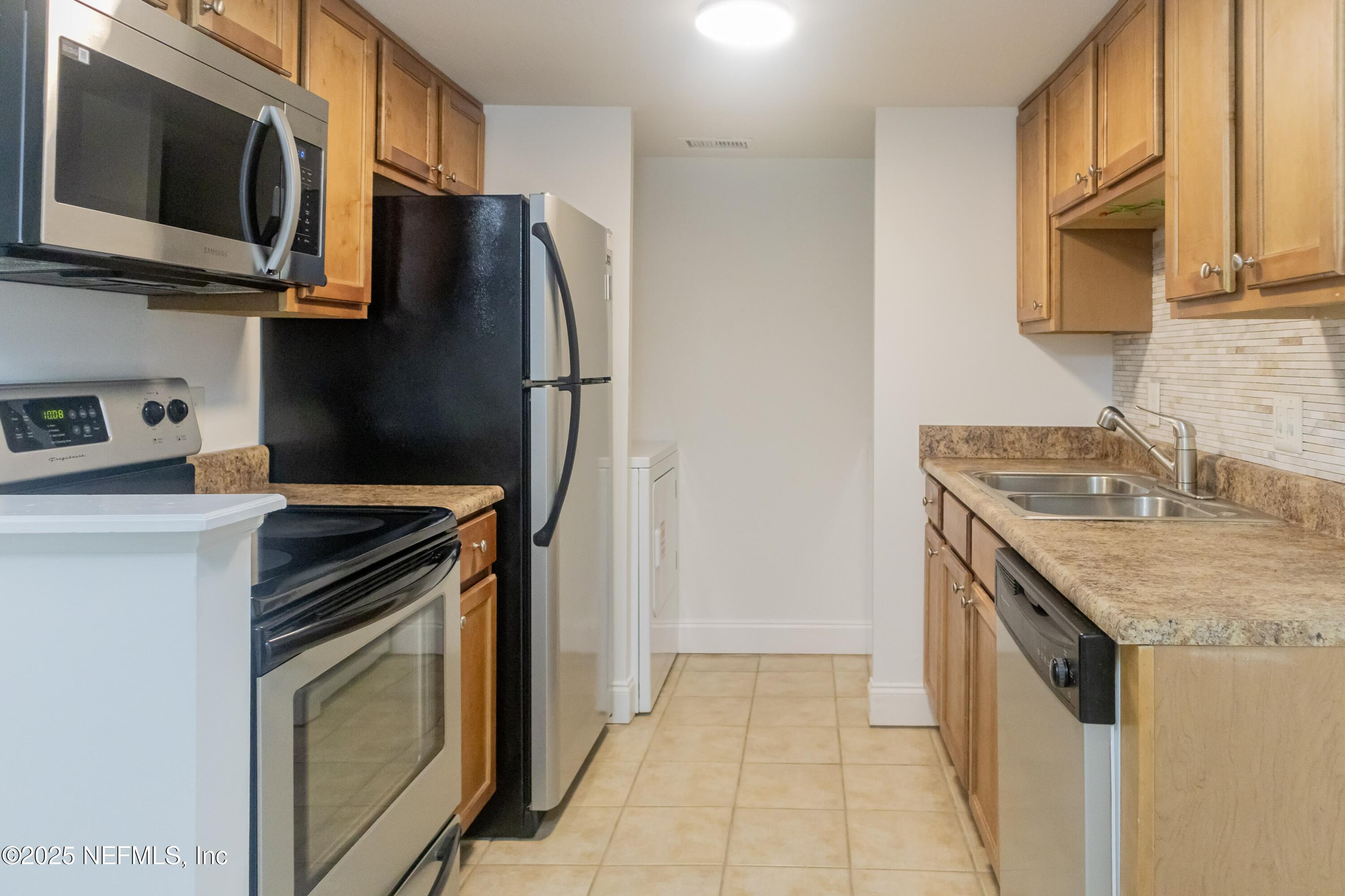 3737 Loretto Road, Unit 114 Jacksonville, FL 32223 - Photo 2 of 11 a kitchen with stainless steel appliances granite countertop a refrigerator stove and microwave