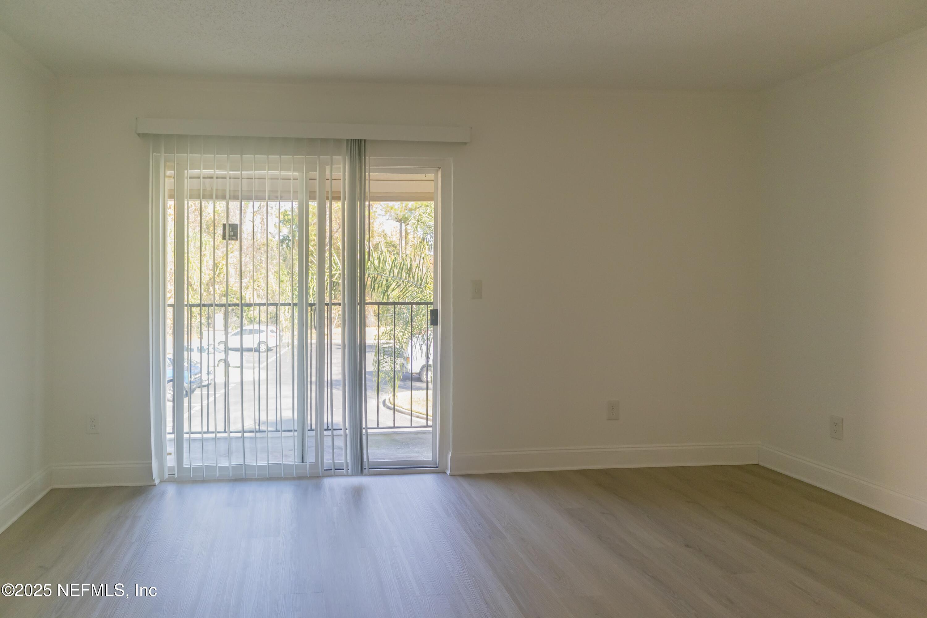 3737 Loretto Road, Unit 114 Jacksonville, FL 32223 - Photo 3 of 11 a view of an empty room with wooden floor and a window
