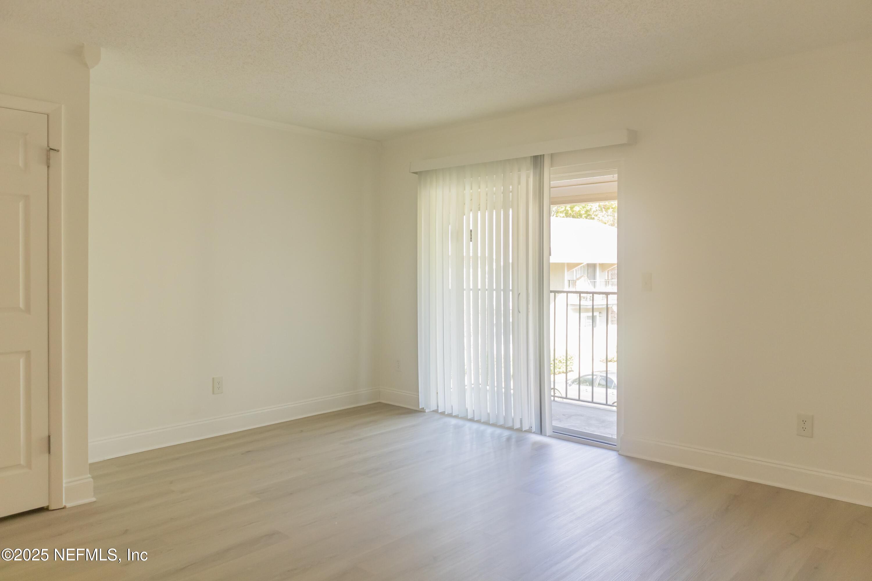 3737 Loretto Road, Unit 114 Jacksonville, FL 32223 - Photo 5 of 11 a view of an empty room with wooden floor and a window